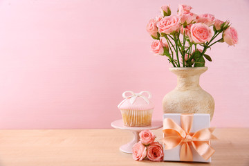 Fototapeta na wymiar Mother Day concept. Roses with cupcake on pink background