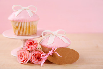 Mother Day concept. Roses with cupcake on pink background