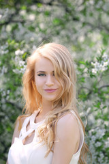 Naklejka premium Young beautiful woman on blooming tree background