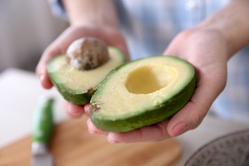Woman holding fresh avocado in kitchen © Africa Studio