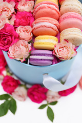 Obraz na płótnie Canvas Tasty macaroons and roses in box, closeup