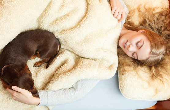 Woman With Dog Waking Up In Bed After Sleeping.