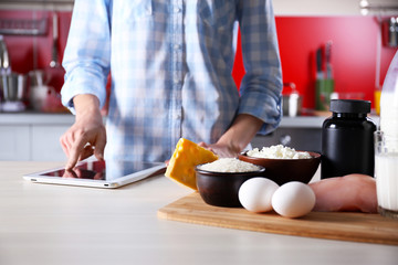 Woman reading recipe from tablet  in the kitchen