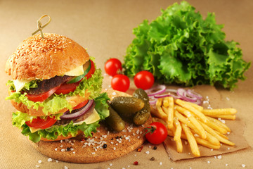 Double hamburger with fries on paper background