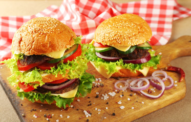 Double hamburgers on wooden cutting board