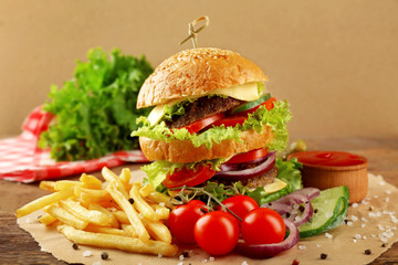 Hamburger with fries on wooden table