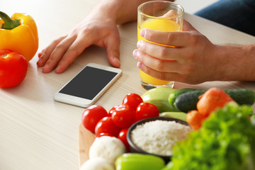 Man counting calories on table