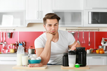 Man with healthy food and sports nutrition in kitchen