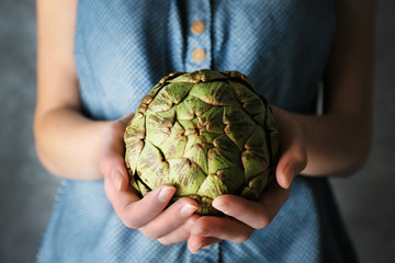 Woman holding artichoke