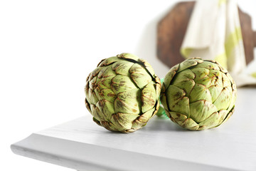 Obraz premium Artichokes on white wooden table