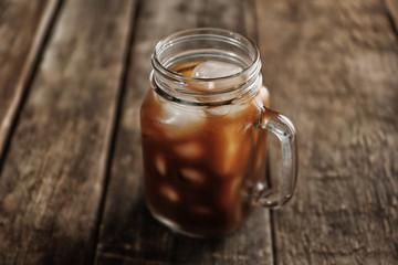 Jar of ice coffee on wooden table