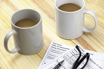 Two EU referendum poll cards on a table with drinks