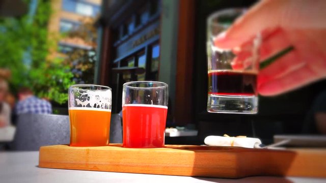 4K Vignette Shot, Beer Tasting Flight, Macro Shot of Hand at Pub, Summer Sun