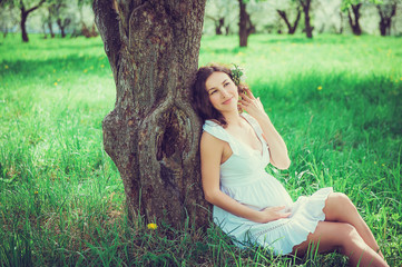 Naklejka na ściany i meble Pregnant beautiful woman in the apple orchard