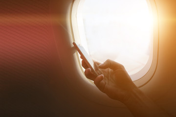 holding mobile phone with flight mode in the airplane