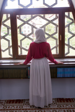 Young muslim woman reading koran