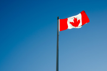 Canadian flag waving over blue sky