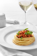 italian bolognese spaghetti on a plain white plate
