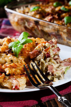 Portion of fusilli pasta casseroles, sausages and zucchini