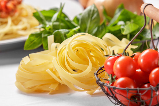 raw italian tagliatelle pasta and cherry tomatoes