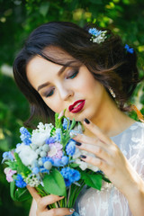 Naklejka premium Beautiful bride in a dress the colors of serenity with a bouquet of flowers.