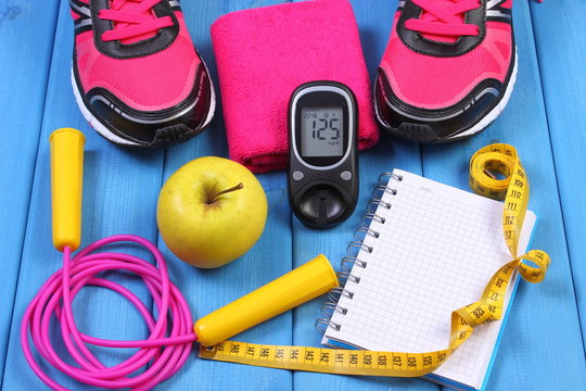 Glucometer, sport shoes, fresh apple and accessories for fitness on blue boards, copy space for text