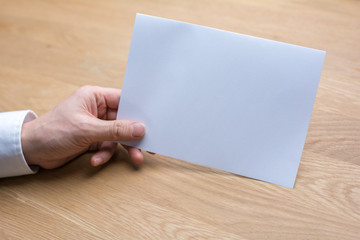 businessman holding white blank paper