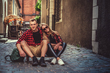 Cheerful longboarders couple posing in old town street.