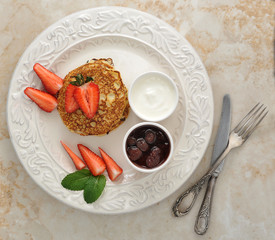 dessert of pancakes with raspberries and sour cream