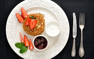 Fototapeta na wymiar dessert of pancakes with raspberries and sour cream