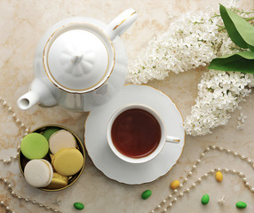 morning tea with cookies, macarons, and a branch of lilac
