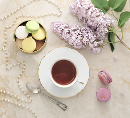 morning tea with cookies, macarons, and a branch of lilac