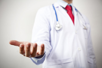 Doctor presenting blank palm of his hand in white background