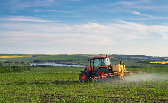Farm machinery spraying insecticide to the green field, agricult