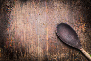 Old cooking spoon on aged wooden background, top view. Food and cooking background for menu or recipes, top view