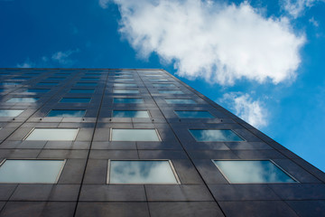Clouds reflected in windows of modern office building