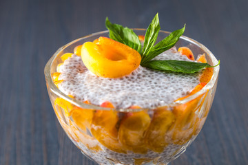 Raw vegan dessert: Chia seeds pudding with apricots on a wooden background 