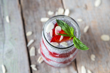 Raw vegan dessert: Chia seeds pudding with strawberries on a wooden background 