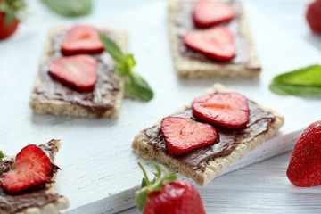 Breads with chocolate and strawberry on wooden table