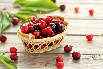 Ripe cherries in basket on a grey wooden table