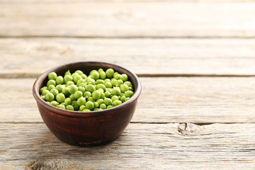 Green peas on a grey wooden table