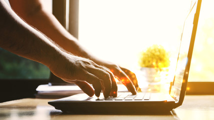 Man's hands using laptop.