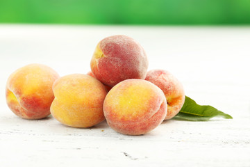 Ripe peaches fruit on a white wooden background