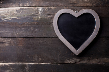 Wooden heart with blackboard on old brown wood