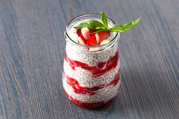 Raw vegan dessert: Chia seeds pudding with strawberries on a wooden background 