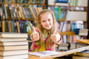 teen girl in library showing thumbs up