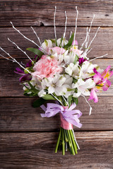 Rustic bouquet from gillyflowers and white alstroemeria on old,