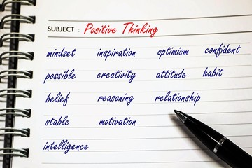 handwriting about positive thinking concept on note book with a pen