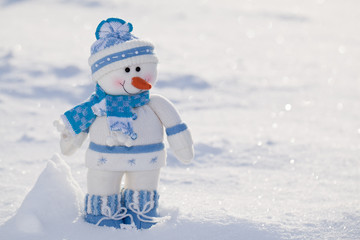 Little snowman with carrot nose in the snow.