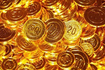 Golden coins piled in a heap of background